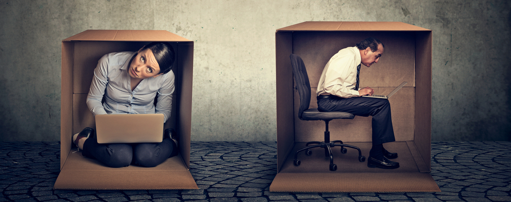 Man and woman sitting inside different boxes working on laptop computer not communicating