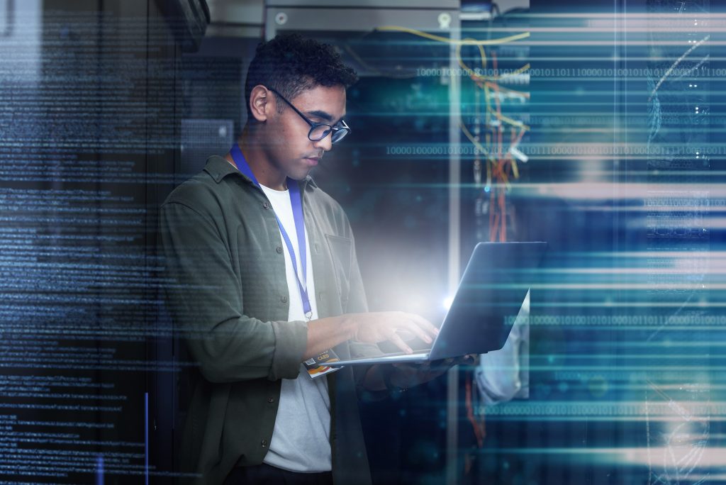 Server room, laptop and man with date overlay for cyber security, programming and writing software code. Technician person or geek in data center for motherboard or firewall system assessment at work.