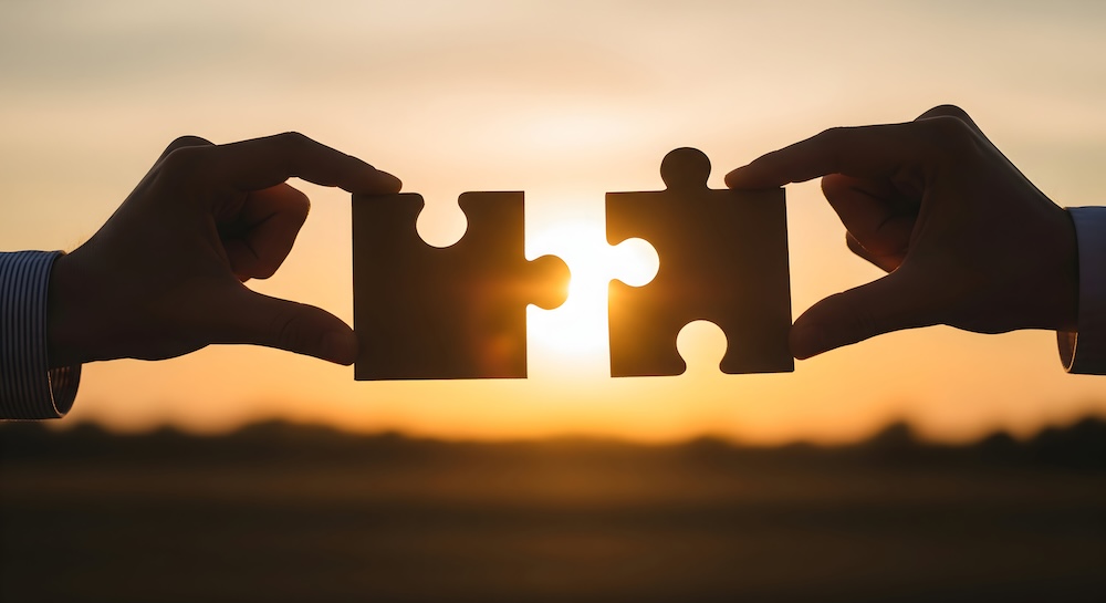 Connecting Puzzle Pieces at Sunset: Symbolizing Teamwork and Solutions