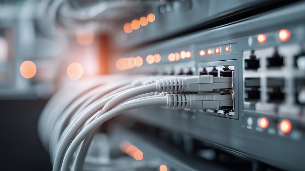 Data center network switch with multiple ethernet cables connected representing backbone infrastructure for enterprise communication.